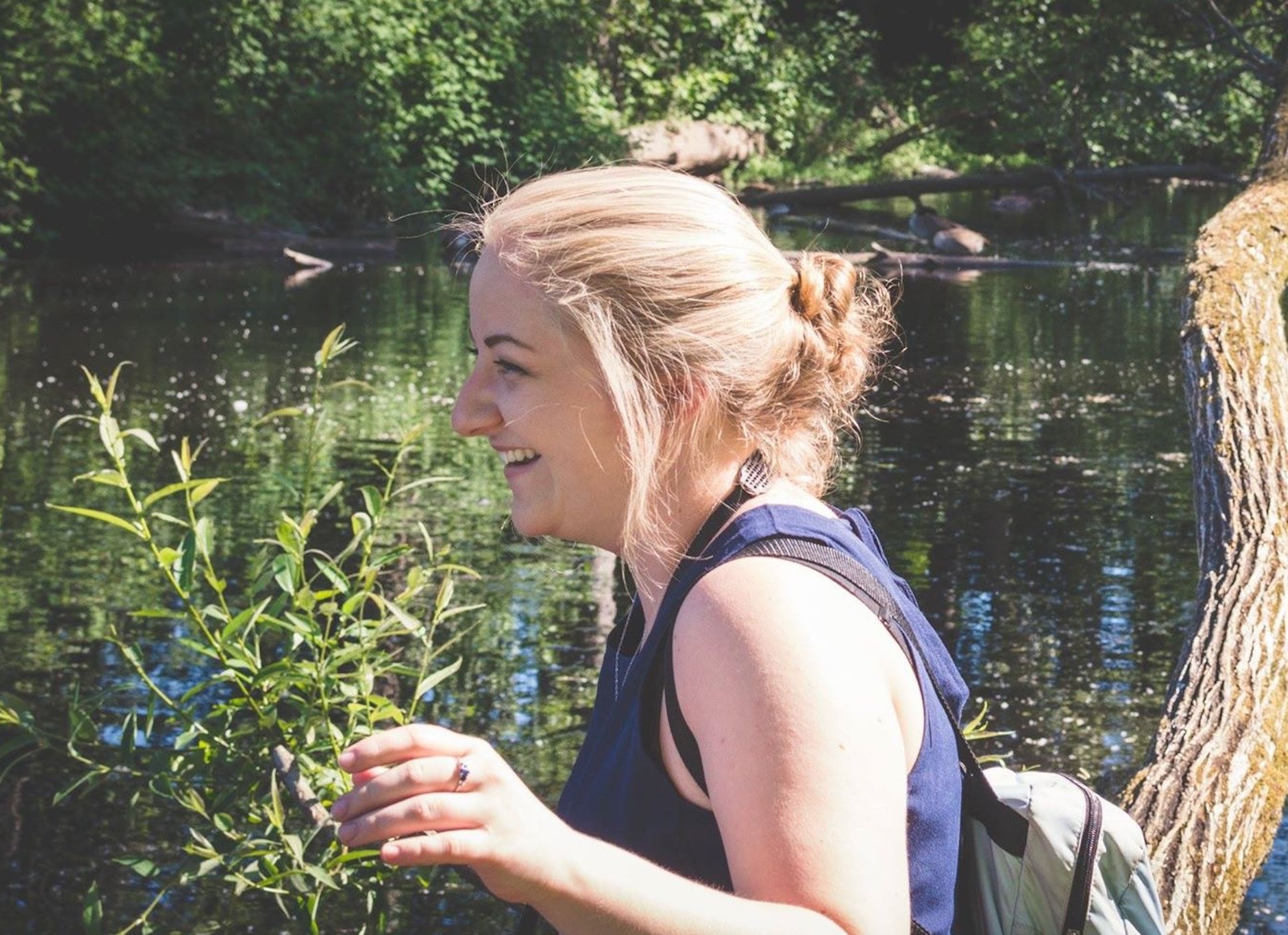 Brianna outdoors beside a wooded pond
